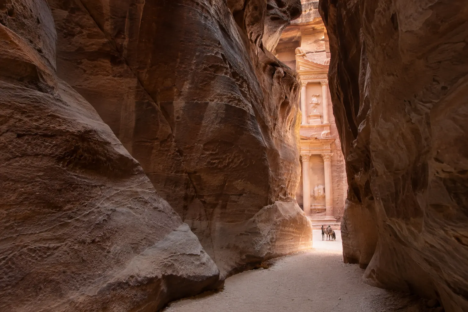 Défilé de grès rose du Sîq laissant apparaître le Trésor de Pétra en Jordanie