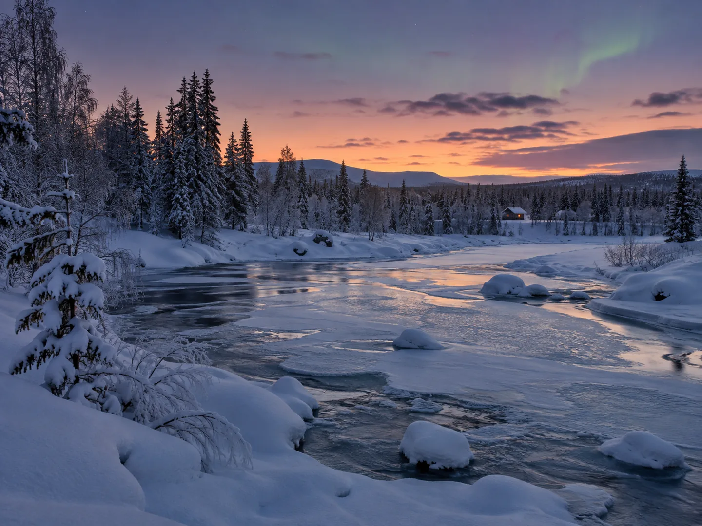 Rivière partiellement gelée dans une forêt enneigée en Laponie finlandaise
