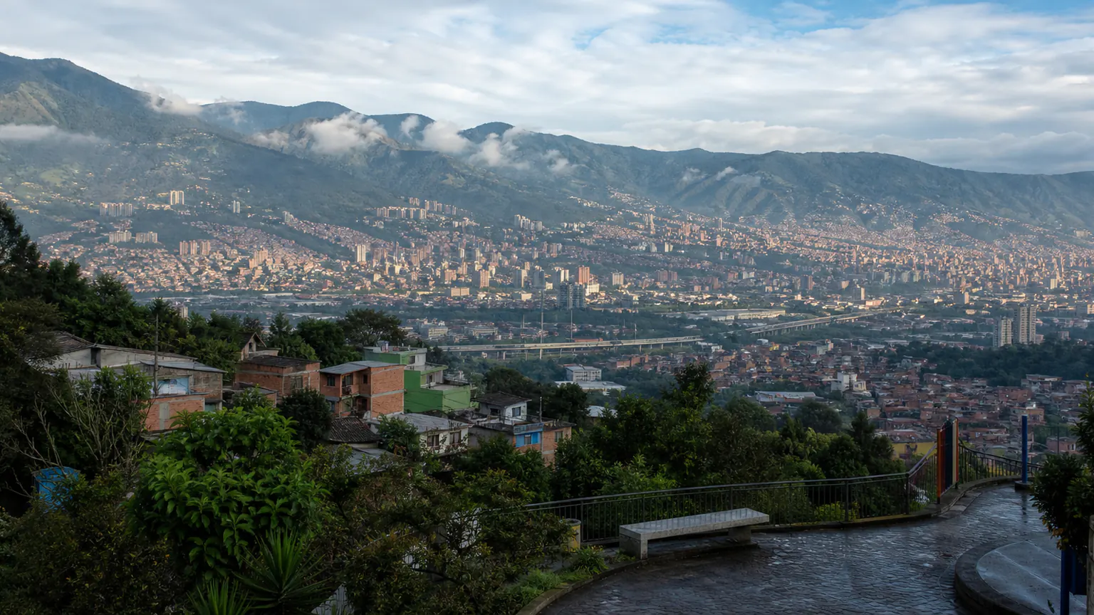 Vue de Medellín depuis un belvédère arboré après la pluie, entre ville et reliefs andins