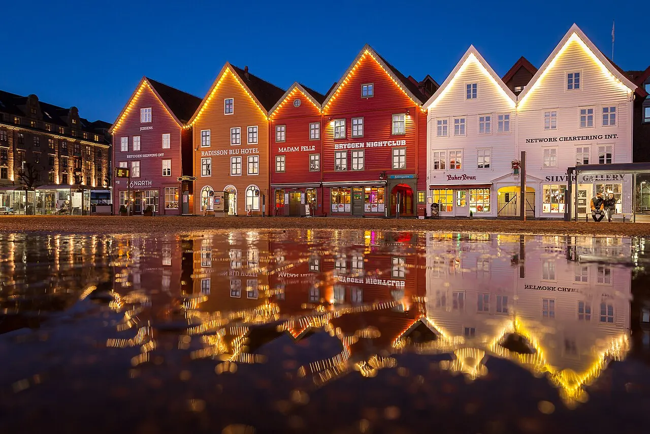 Façades de Bryggen et reflets sur le sol humide à Bergen